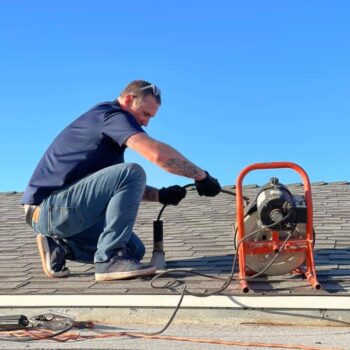 HVAC technician repairing roof unit