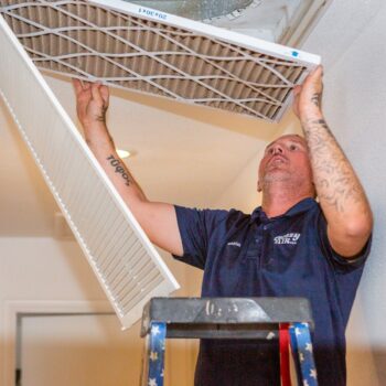 HVAC technician replacing air filter